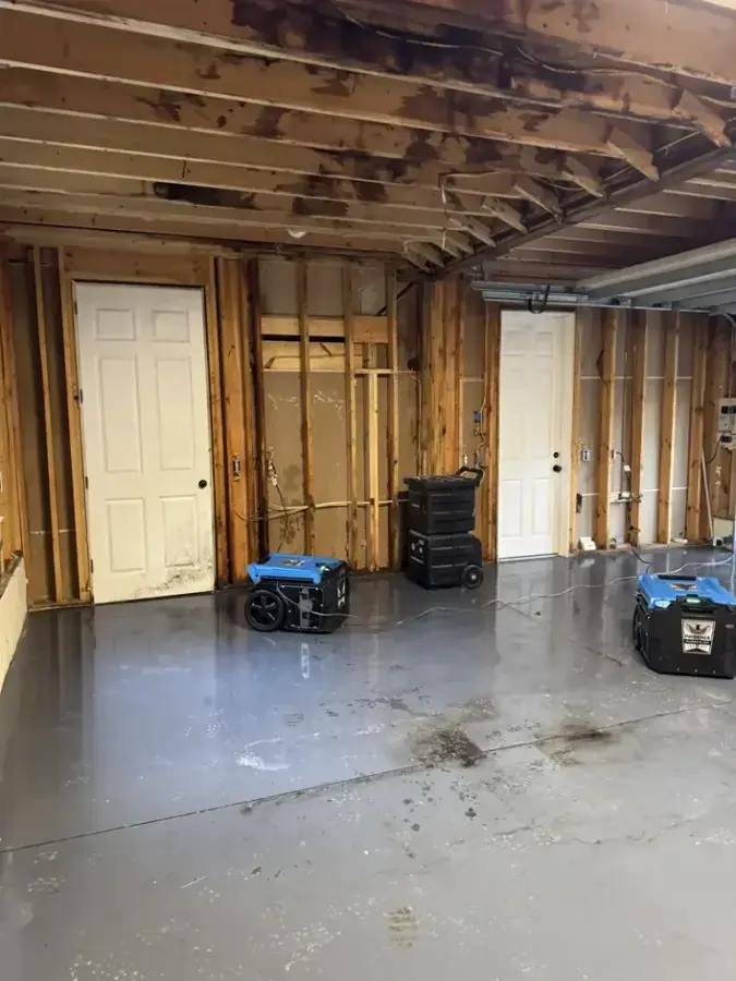Dehumidifiers drying a gutted lower level after water damage near Huntersville