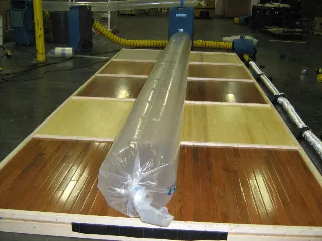 Hardwood floor panels under a drying system after a water loss