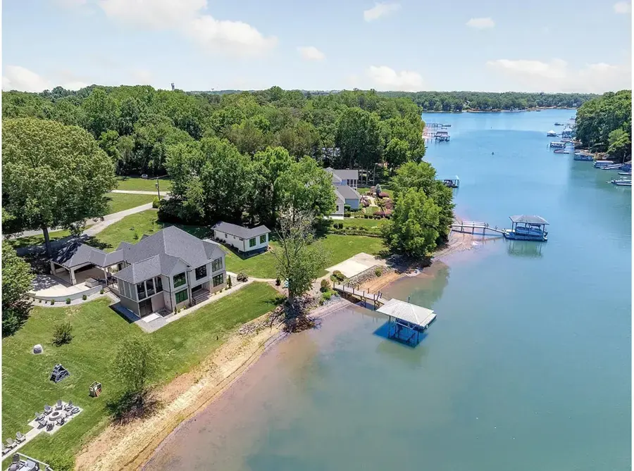 Aerial of lakefront homes, lawns and boat docks on a cove